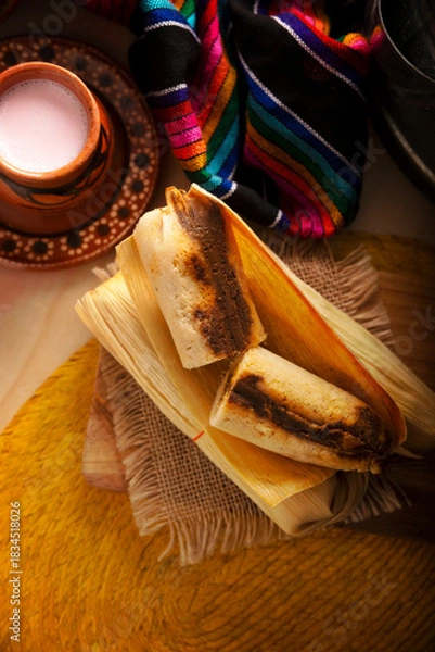 Fototapeta Tamales. Traditional dish typical of Mexico and some Latin American countries. Corn dough wrapped in corn leaves. The tamales are steamed.