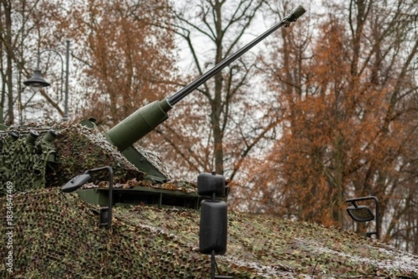 Fototapeta Light tank with a mounted autocannon pointing towards the sky