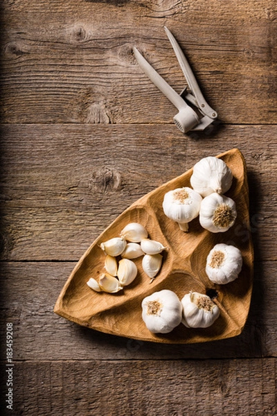Fototapeta Garlic, Garlic cloves and Garlic bulb in vintage handmade wooden bowl. Top view.