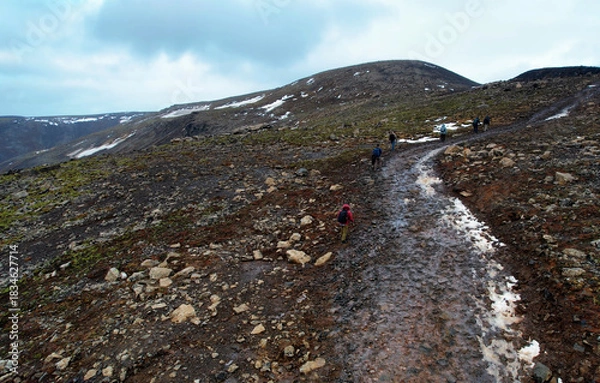 Fototapeta A group of hikers trekking along the Fagradalsfjall trail to view the lava field from recent eruption