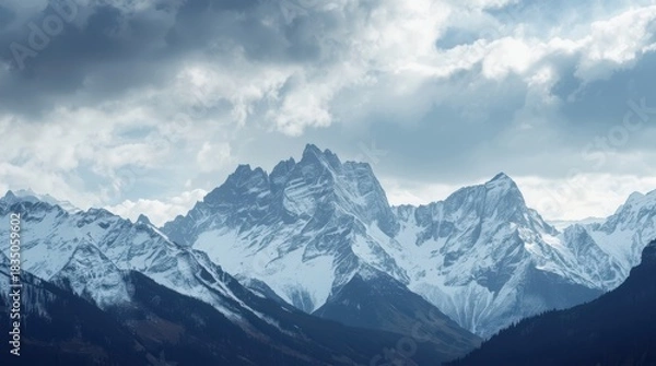 Obraz Majestic snow-capped peaks under a dramatic, cloudy winter sky, rugged terrain, hints of alpine trees, epic scale, symbolic of enduring strength. Generative AI