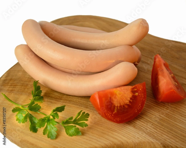 Fototapeta Raw fresh sausage with tomatoes and parsley on wooden desk isolated on white