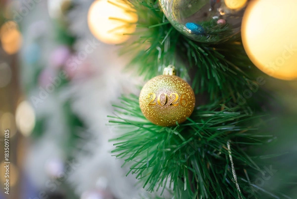 Obraz close-up of christmas tree branches with holiday ornaments and garlands. one of the ornaments is a funny red horse, symbol of 2026
