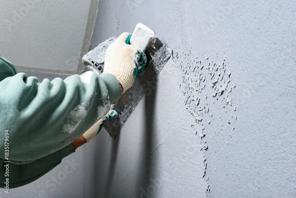 Fototapeta Applying concrete pebble plaster kornik using putty knife.