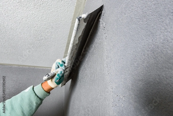 Fototapeta Applying concrete pebble plaster kornik using putty knife.