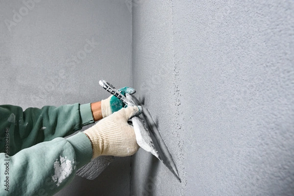Fototapeta Applying concrete pebble plaster kornik using putty knife.