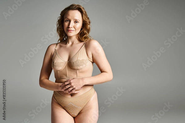 Obraz Celebrating natural beauty with confidence in a grey studio setting