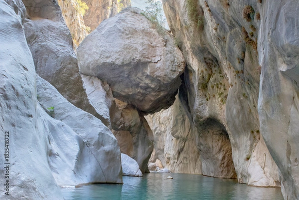 Obraz Massive boulder suspended between Goynuk canyon walls, Turkey. Stunning narrow gorge with hanging giant rock above turquoise waters.