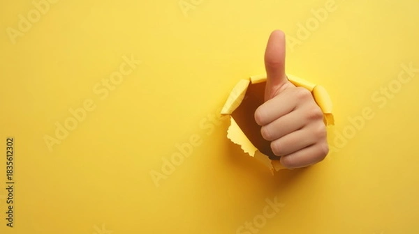 Obraz Hand giving a thumbs up through a torn yellow background, expressing positivity and approval in a vibrant setting Generative AI