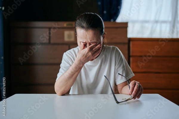 Fototapeta メガネを持ちながら目を押さえるシニア女性