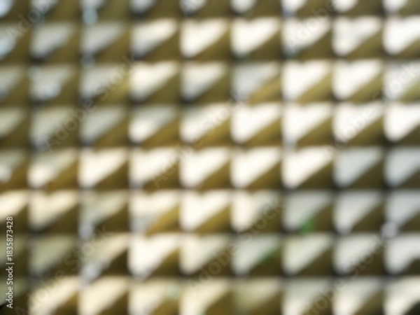 Fototapeta Close-up of a blurred abstract triangle pattern in golden color. Decorative blurred abstract pattern for outdoor wall application.