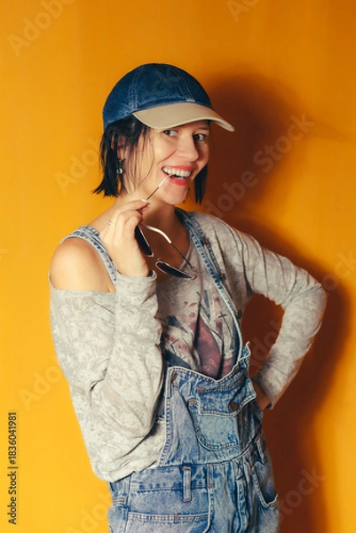 Obraz Smiling woman posing playfully with sunglasses