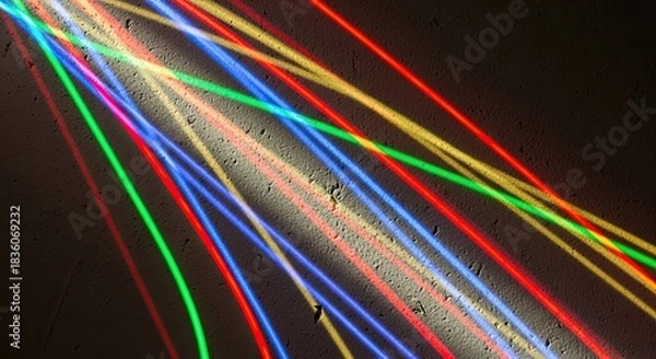 Fototapeta Colorful light streaks cast vibrant shadows on a textured wall creating a modern abstract design with dynamic lines and playful energy for backgrounds and creative projects