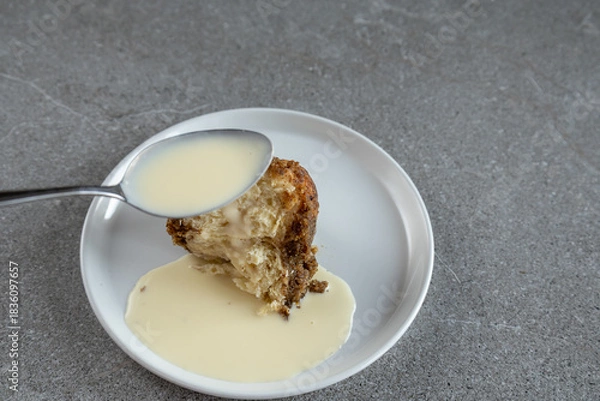Fototapeta Traditional sweet dumpling dessert and a spoonful of vanilla cream sauce, monkey bread