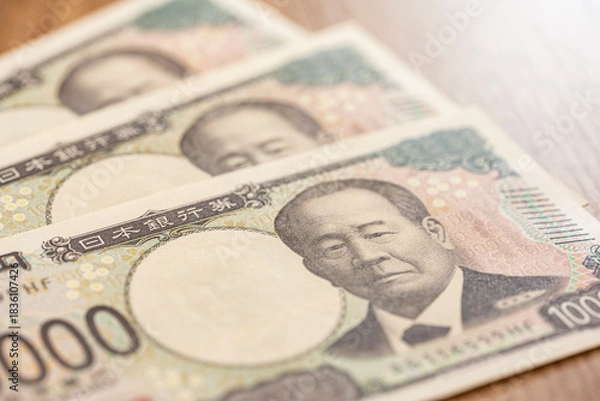 Obraz 木目テーブルに並べた一万円札が示す日本円の高額現金イメージ