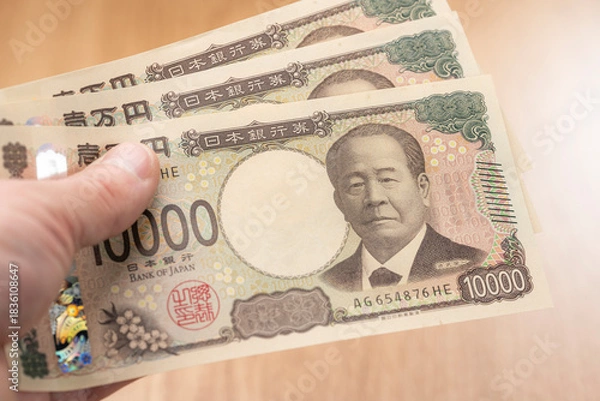 Obraz 一万円札を手に持つ日本円の現金と資金イメージ