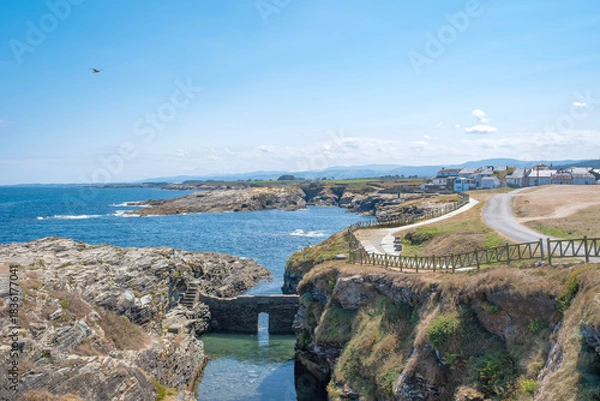 Obraz path along the coast in the small fishing village of Rinlo, Lugo, Spain, with the old natural fish farm in the foreground
