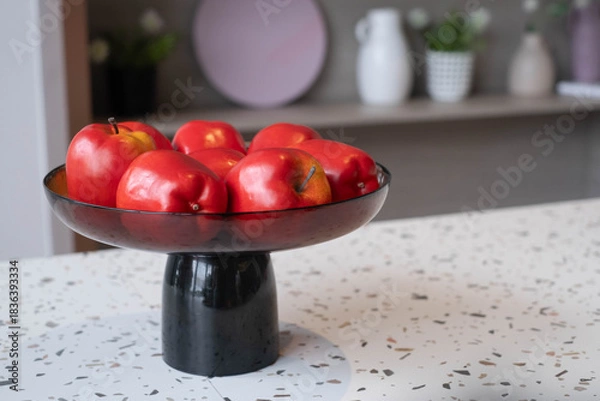 Fototapeta Red apples arranged in a modern decorative bowl on a stylish tabletop, highlighting healthy lifestyle, home decor, freshness, interior aesthetics, and natural food presentation in a cozy living space.
