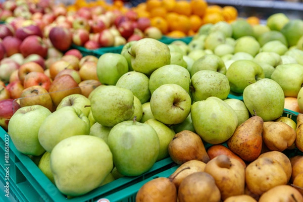 Fototapeta apples of different colors on display in a market