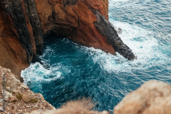 Obraz Rocky coastal cliff with turquoise waves crashing against the shore, showcasing the beauty of nature and the power of the ocean in a serene landscape