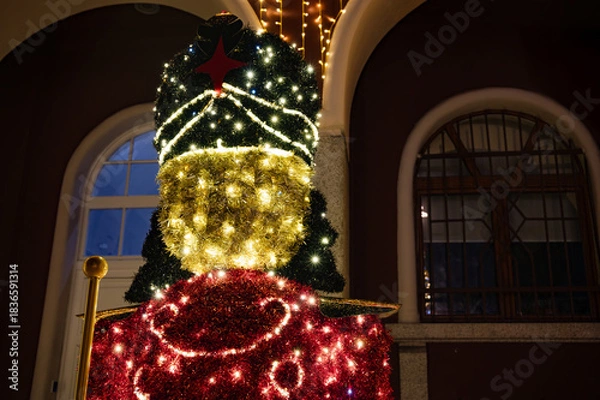 Fototapeta Festive decorative Christmas soldiers adorned with glowing string lights on a public square in Durrës, Albania.