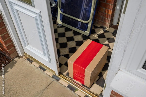 Fototapeta Online shopping parcel delivery left inside open porch doorway from outside