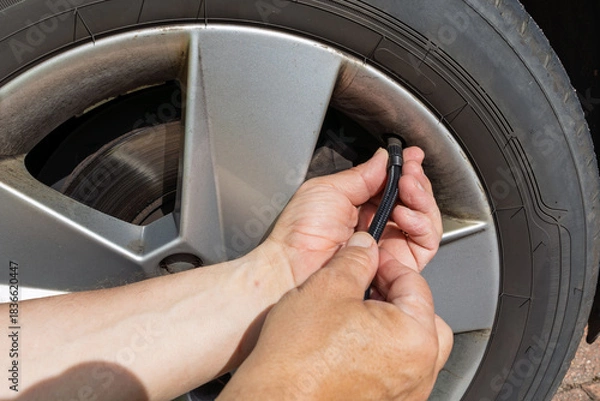 Fototapeta Attaching Air Hose to Car Tyre Valve for Inflation