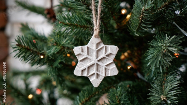 Fototapeta Whitewashed carved wooden snowflake ornament hanging on a Christmas tree branch with warm lights