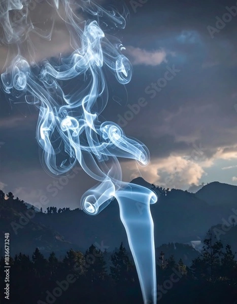 Obraz Wispy column of smoke against a cloudy, forested mountain backdrop