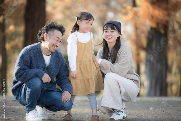 Obraz 秋の公園で遊ぶ家族 紅葉の森で笑顔の親子の記念撮影　お出かけやレジャーのほのぼの思い出のイメージ