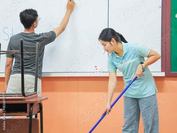 Obraz Asian teacher woman cleaning classroom at school. People clean housework college. Back to school. Education knowledge learning. Chore of student 