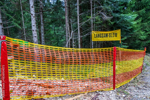 Fototapeta Slow down sign in a rural area with cloudy sky and barren landscape