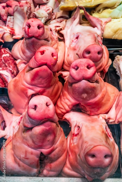 Fototapeta Freshly displayed pork cuts at a bustling market showcasing various meat parts and offal, attracting shoppers on a lively afternoon
