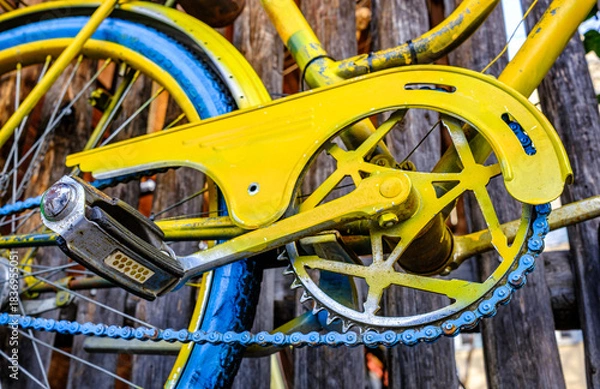 Fototapeta Vintage blue bicycle leaning against a colorful wall in bright sunlight during afternoon hours in an urban setting