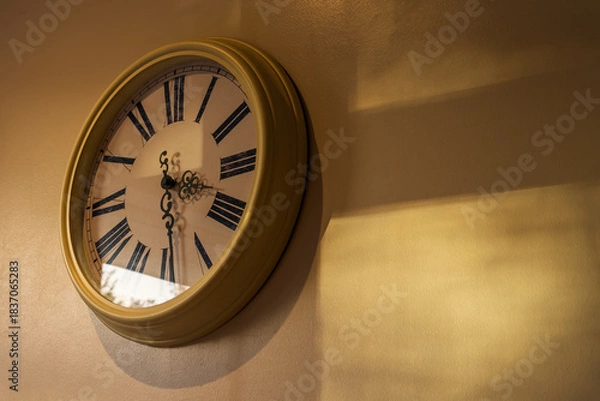 Fototapeta Analogue clock with the last sunlight of the day on the wall, idea of the passage of time or a journey with copy space for your text