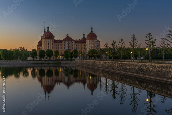 Fototapeta A tranquil night twilight shot of Moritzburg Castle from a closer perspective, capturing part of the castle garden and architectural details