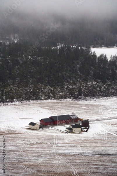 Fototapeta Foggy Early Winter Landscape with Traditional Red Farm Houses amidst Fields Near Trillemarka-Rollagsfjell Nature Reserve, Prestfoss, Norway