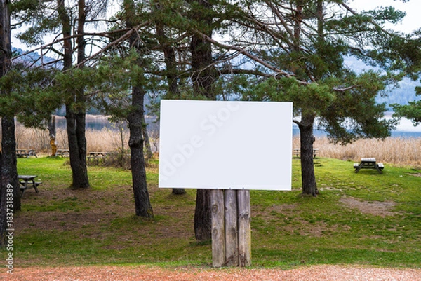 Fototapeta Blank White Sign on Wooden Posts in a Scenic Park
