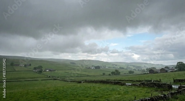 Fototapeta Dramatic green rolling countryside scene endures a gentle summer rain under moody clouds