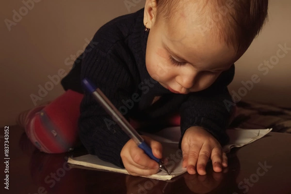 Fototapeta A child showing serious concentration while learning new skills