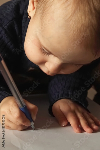 Fototapeta A child practicing fine motor skills during an early learning moment.