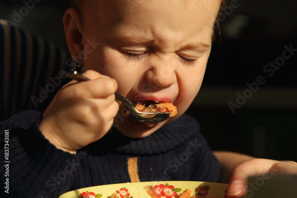 Fototapeta A child expressing strong emotions during early self-feeding attempts.