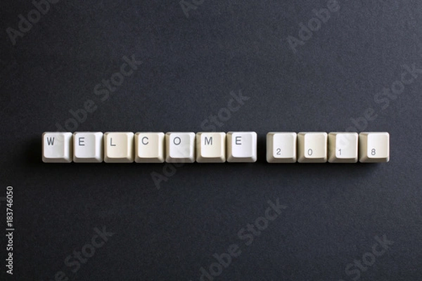 Fototapeta Welcome 2018 New Year. Flat lay view from above on the table with computer keyboard keys buttons on a dark background.
