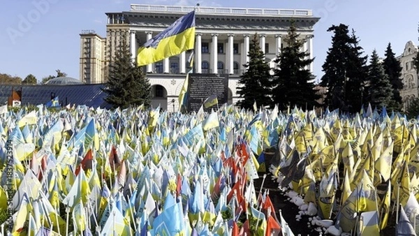 Obraz Many small blue-yellow flags with names of the dead war against russia. Memorial of the fallen soldiers, children, women in the capital of Ukraine. Concept of tragedy and misfortune. Close up