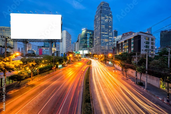 Fototapeta Blank template for outdoor advertising or blank billboard with light trail to business district in twilight.