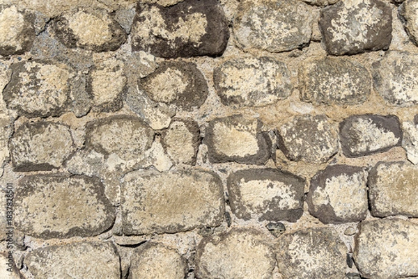 Obraz Masonry of a wall made of grey round and oval stones bonded with cement and lime mortar