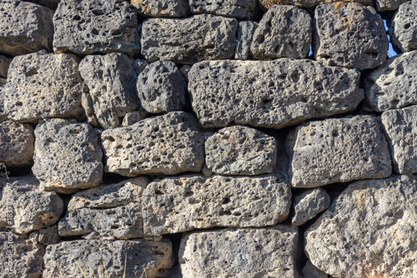 Obraz Laying a wall of uneven dark gray stones of different sizes