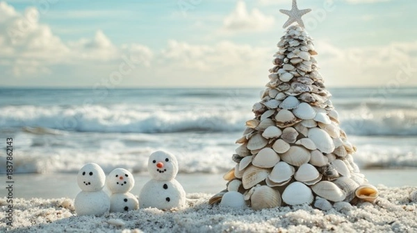 Fototapeta Christmas tree made of seashells on beach, sand snowmen, ocean backdrop .
