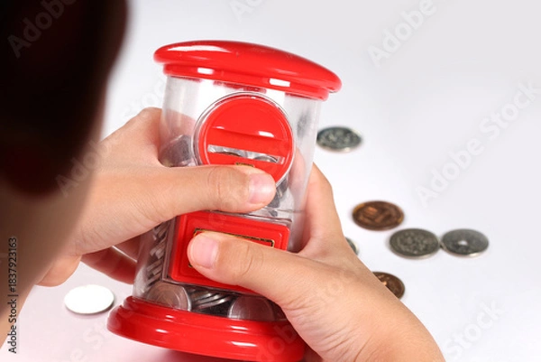 Obraz 貯金箱を持つ子どもの手