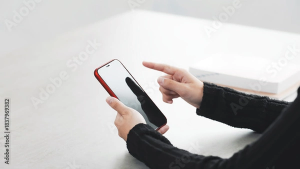 Obraz 部屋でスマホを使う女性